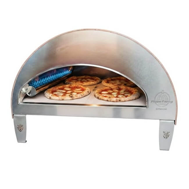 A front view of the antique copper Pizza Party Ispirazione gas pizza oven with pizzas cooking inside on a white background.