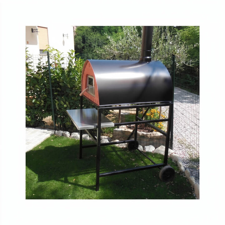 Passione pizza oven mounted on a black stand and set up in a garden.