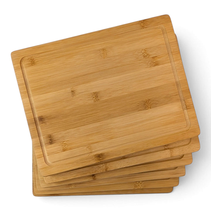 Six rectangular bamboo serving boards stacked slightly offset on a clean white background.