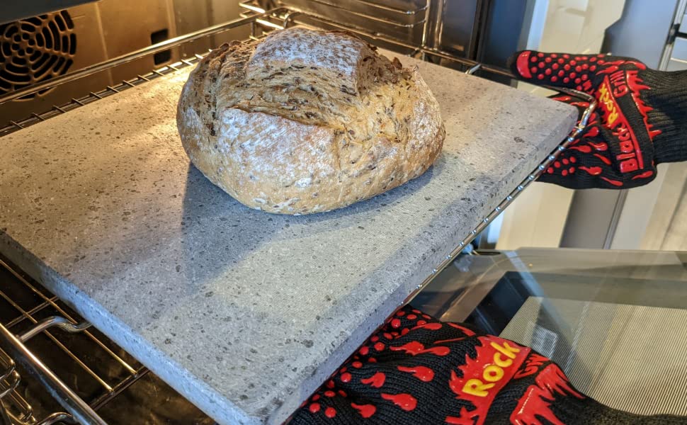 lava baking stone for bread, pizza, bread and more coming out of oven with a freshly baked loaf in the center